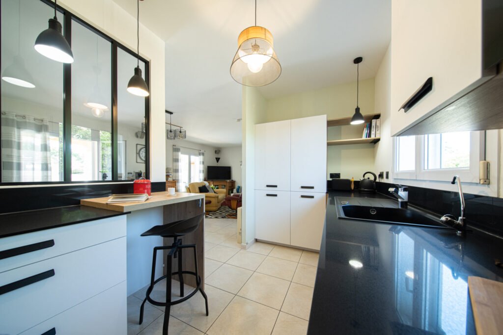 Cuisine façades blanches et plan de travail noir, avec coin repas, verrière par Kty.L Intérieurs, UFDI, Avignon, Nîmes, Uzès